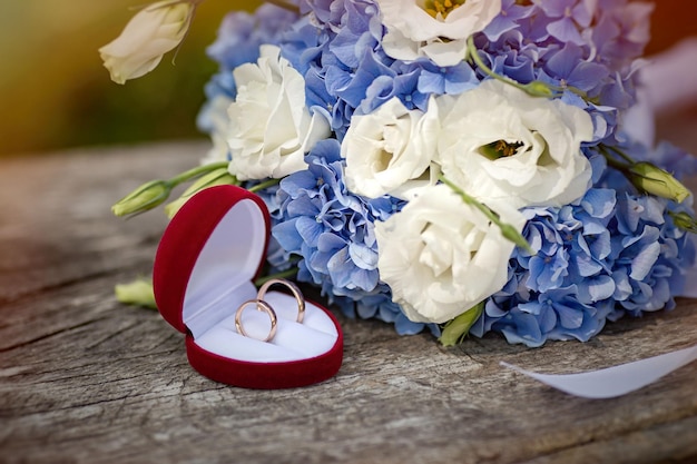 Bellissimo bouquet da sposa con fedi nuziali su una tavola di legno foto di alta qualità