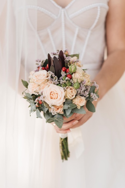 Bellissimo bouquet da sposa con protea e rose nelle mani della sposa