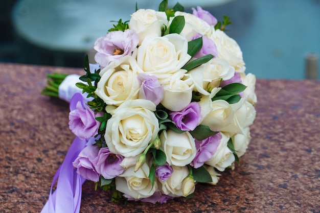 Bellissimo bouquet da sposa di fiori naturali su uno sfondo sfocato si trova su granito