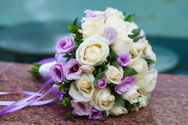 Bellissimo bouquet da sposa di fiori naturali su uno sfondo sfocato si trova su granito