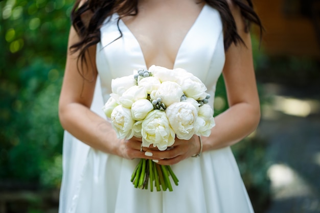 Bellissimo bouquet da sposa di fiori nelle mani degli sposi