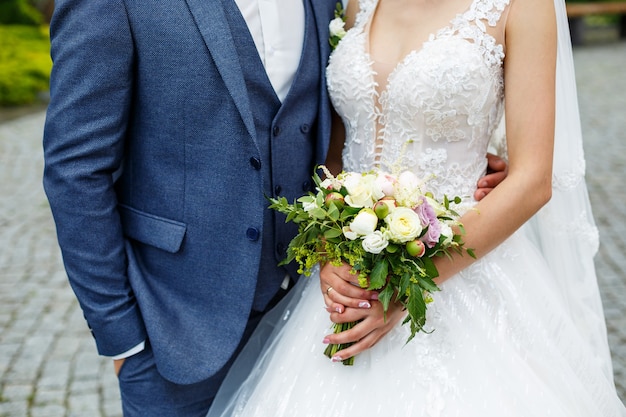 Bellissimo bouquet da sposa di fiori nelle mani degli sposi