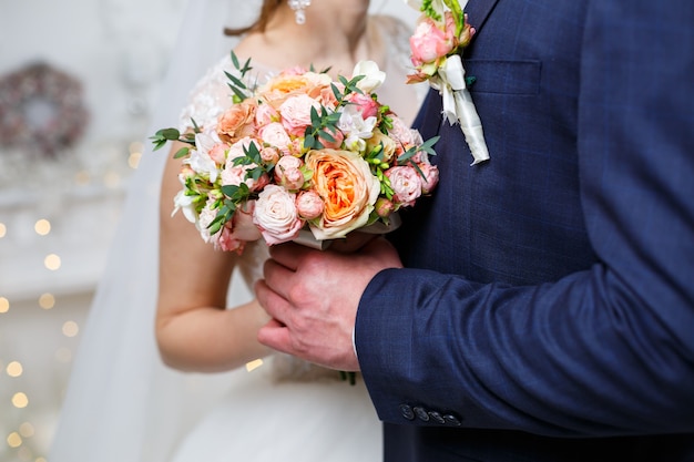 Bellissimo bouquet da sposa di fiori nelle mani degli sposi