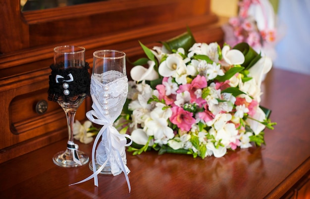 Bellissimo bouquet da sposa e due bicchieri di champagne