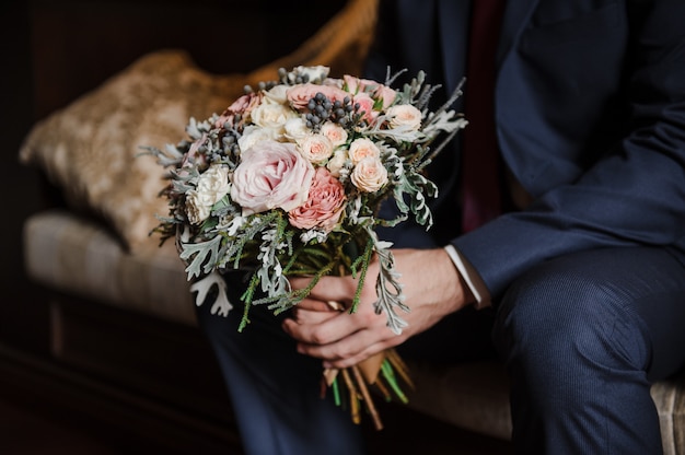 Bellissimo bouquet da sposa. Floristica per matrimoni. Un bouquet nelle mani dello sposo.