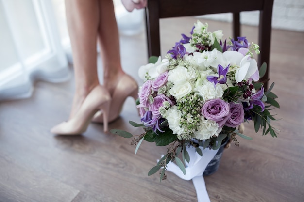 Bellissimo bouquet da sposa in un secchio o scatola decorativa e le gambe della sposa