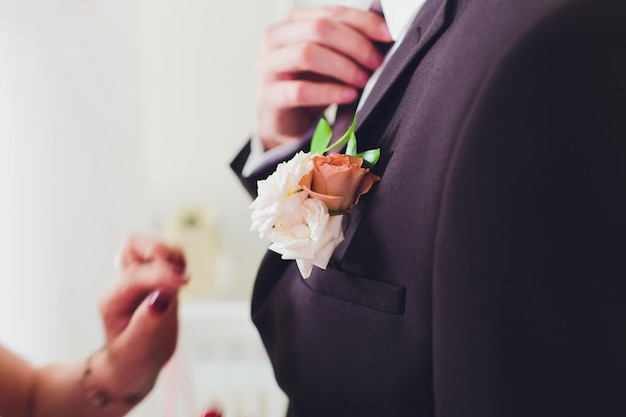 Bellissimo bouquet da sposa nelle mani della sposa con rose Giorno del matrimonio Bokeh Sposa Bouquet della sposa Fiori nuziali Il bouquet è decorato con una spilla