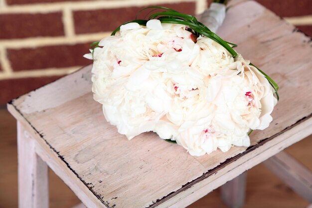 Bellissimo bouquet da sposa su scala di legno su sfondo di mattoni
