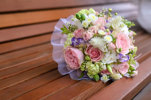 Bellissimo bouquet da sposa su un primo piano di una panca in legno marrone