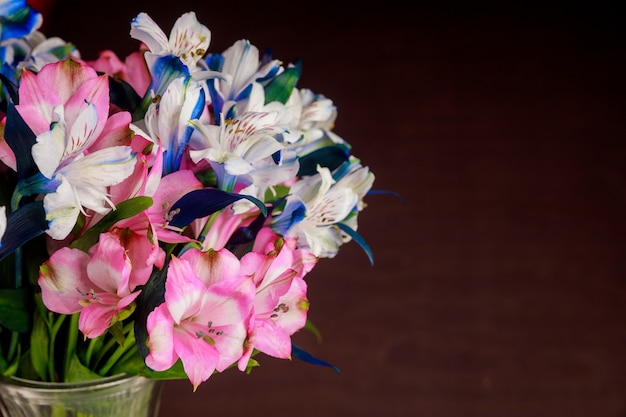Bellissimo bouquet di alstroemerie bianche, rosa e blu su superficie scura. Avvicinamento.
