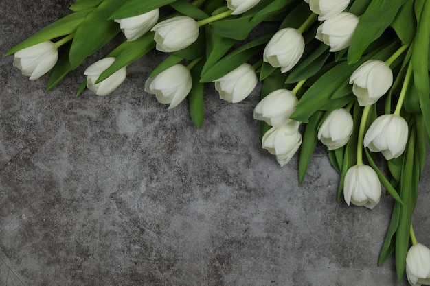 Bellissimo bouquet di fiori di tulipano bianco con carta su sfondo grigio spazio per il testo