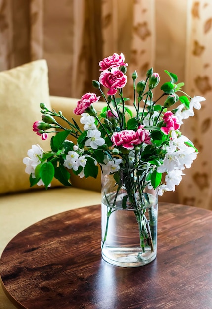 Bellissimo bouquet di garofani rosa e fiori di mela su un tavolo di legno in una stanza accogliente Interni di natura morta domestica