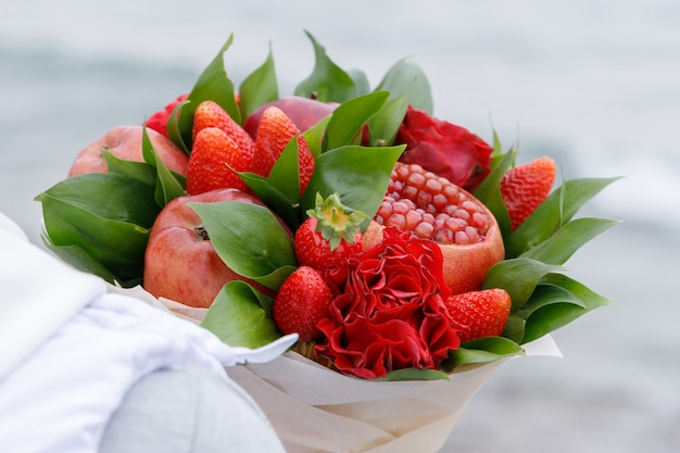 Bellissimo bouquet di mele, melograno, fragole e fiori