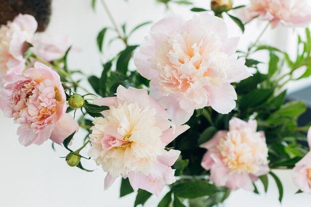 Bellissimo bouquet di peonie in petali di luce soffusa primo piano Immagine floreale elegante Disposizione di fiori di peonia rosa tenera fresca su sfondo rustico