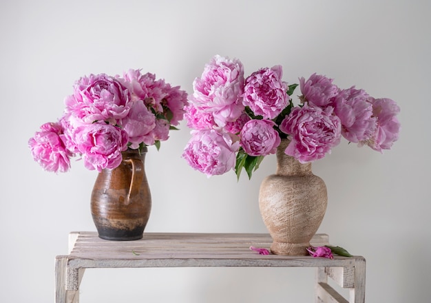Bellissimo bouquet di peonie rosa in vaso su sfondo grigio