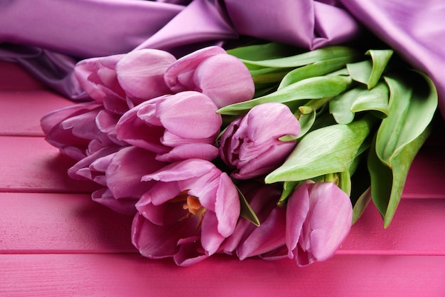 Bellissimo bouquet di tulipani viola su sfondo di legno rosa