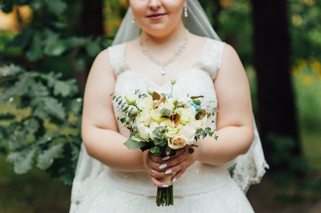 Bellissimo bouquet nelle mani della sposa molto grassa