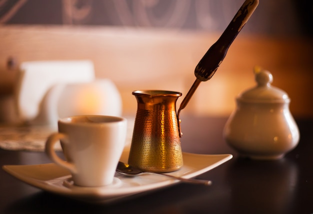 Bellissimo caffè in un interessante design accogliente, sul tavolo una candela, caffè e turka