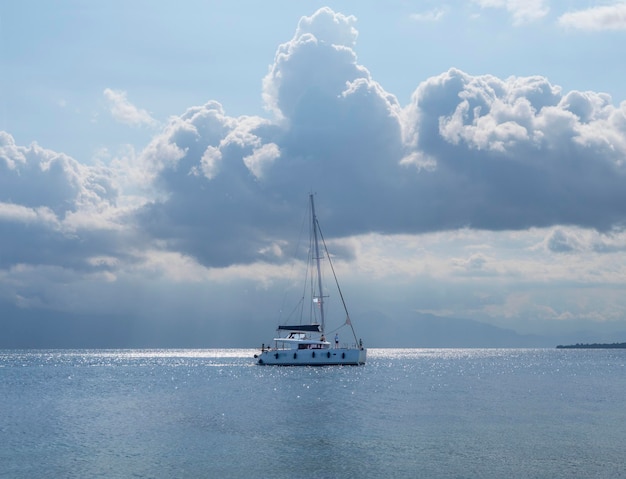 Bellissimo catamarano in una giornata nuvolosa sul calmo Mar Egeo sull'isola di Evia, Grecia