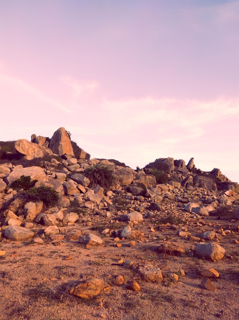 Bellissimo cielo al tramonto rosa blu scuro drammatico con nuvole sopra le montagne di pietra rocciosa