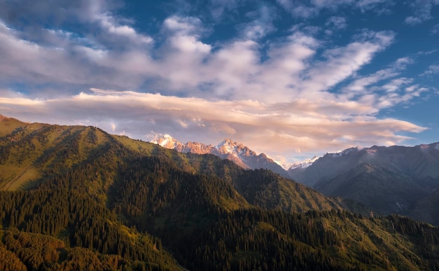 Bellissimo cielo sopra le montagne con foreste e cime innevate Kazakhstan Zailiysky Alatau Ridge Piccola gola di Almaty