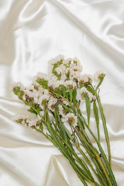 Bellissimo concetto di fiore Bouquet di fiori bianchi in fiore statice su sfondo di stoffa bianca
