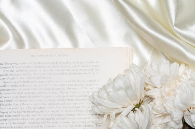Bellissimo concetto di fiore Crisantemo bianco sui libri su sfondo di stoffa bianca