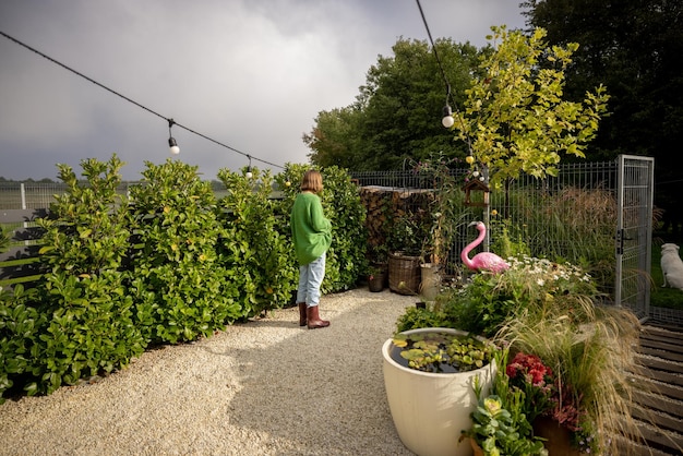 Bellissimo cortile verde con una donna che fa giardinaggio