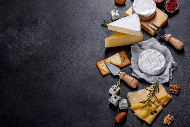 Bellissimo delizioso formaggio camembert, parmigiano, brie con uva e fichi su una tavola di legno. Spuntini per vino in vacanza