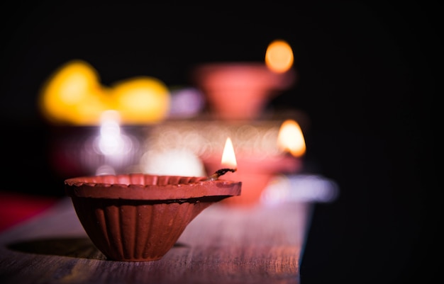 Bellissimo diwali diya con petardi e pera dolce, messa a fuoco selettiva