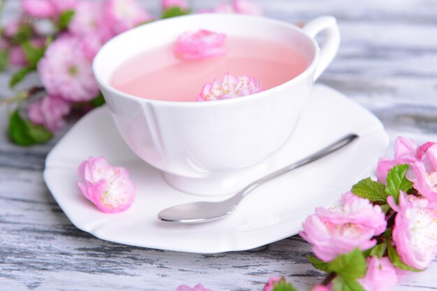 Bellissimo fiore di frutta con una tazza di tè sul primo piano del tavolo