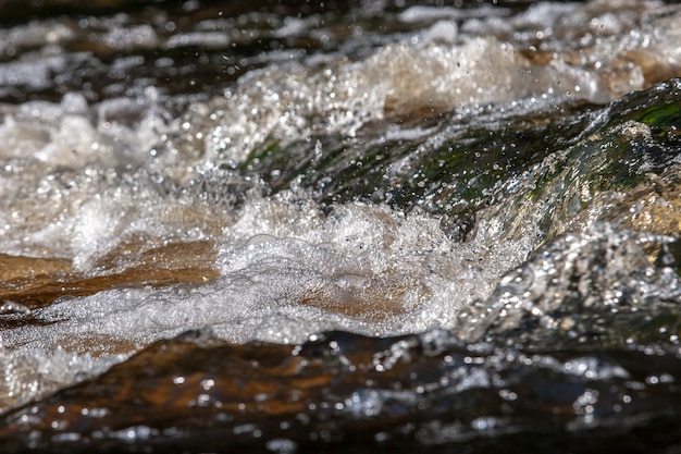 Bellissimo flusso d'acqua con bolle e schiuma