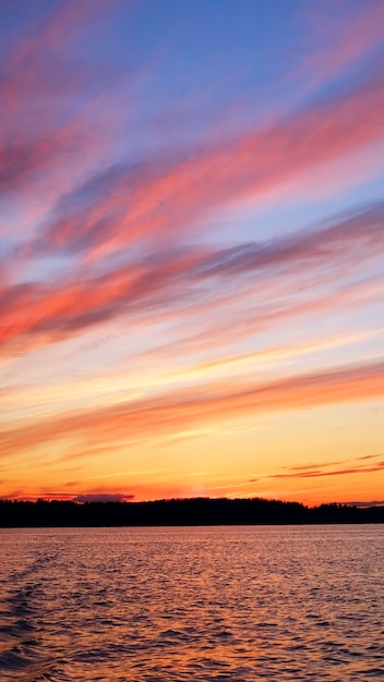 Bellissimo lago al tramonto con nuvole. cornice verticale