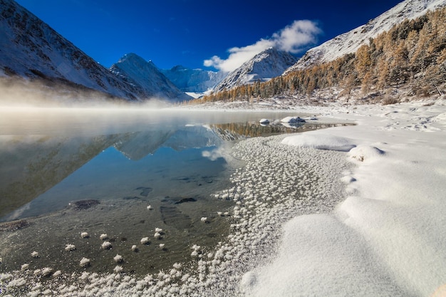 Bellissimo lago di montagna all'alba dopo una nevicata