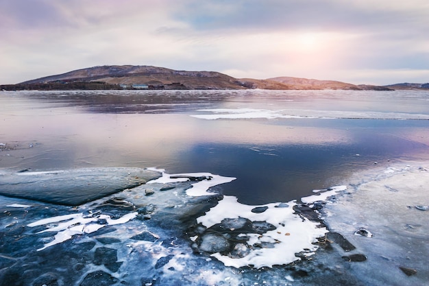 Bellissimo lago invernale con ghiaccio al tramonto. paesaggio invernale