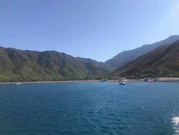 Bellissimo mare blu e piccole navi sullo sfondo di alte montagne in un caldo tropicale turistico