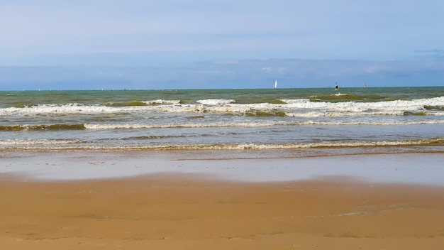 Bellissimo mare con sabbia, yacht, onde sull'acqua e cielo blu. Sfondo naturale per le vacanze estive.