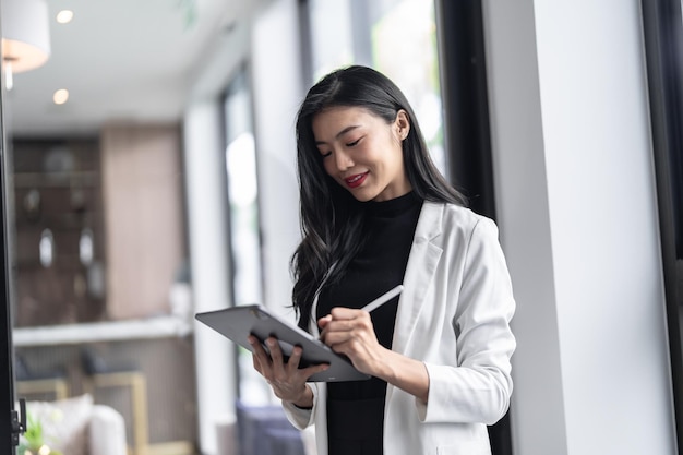 Bellissimo medico asiatico Dottore di professione educativa in camice bianco uniforme Medico professionista con tablet al seminario o al centro benessere ospedaliero