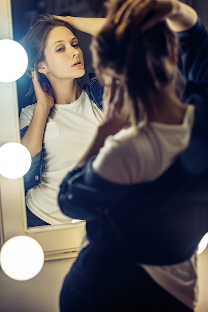 Bellissimo modello femminile in posa vicino allo specchio