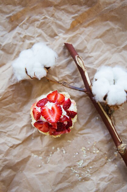 Bellissimo muffin con fragole fresche si trova sulla carta del mestiere