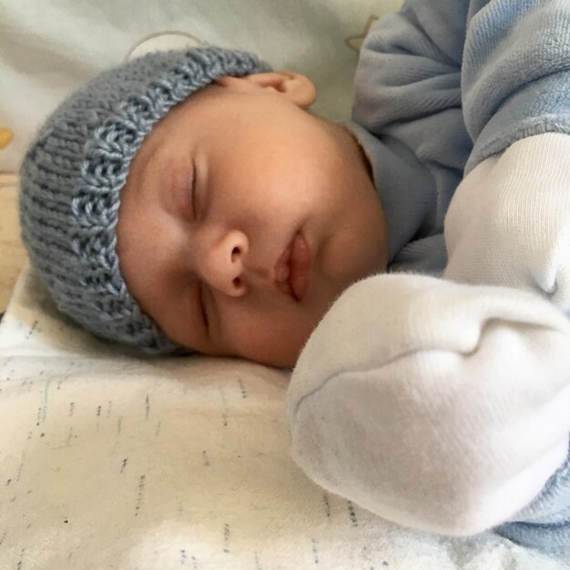 Bellissimo neonato addormentato con cappello bambino in posa fotografo per foto a colori