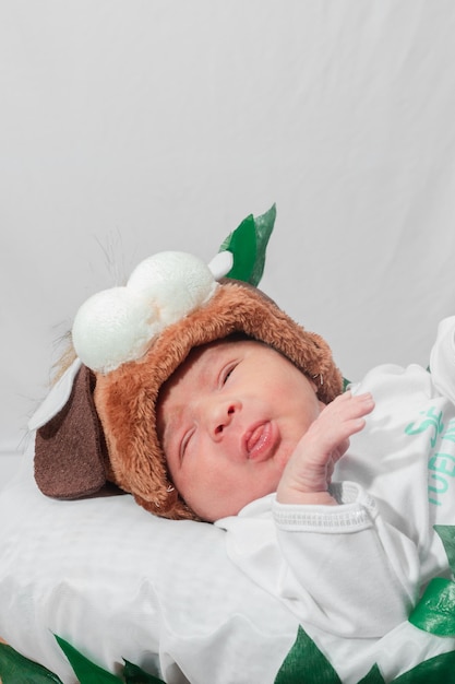 Bellissimo neonato di 4 giorni con cappello e scarpe da cucciolo che sogna nel cestino in fibra di bambù