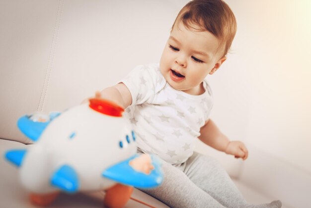 Bellissimo neonato divertendosi e giocando con i giocattoli a casa.