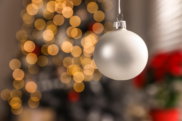 Bellissimo ornamento per le vacanze appeso a luci di Natale sfocate