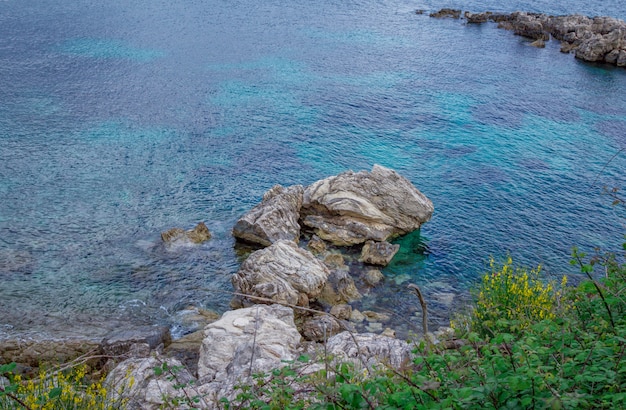 Bellissimo paesaggio con baia sul mare con acqua turchese, rocce e scogliere, alberi verdi e cespugli
