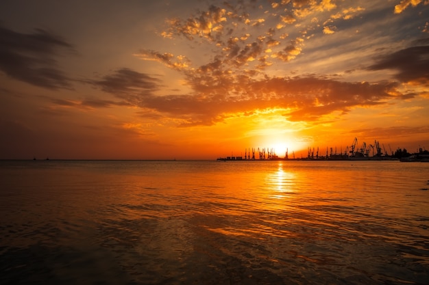 Bellissimo paesaggio con cielo e mare al tramonto infuocati. Porto di Berdyansk durante l'alba.