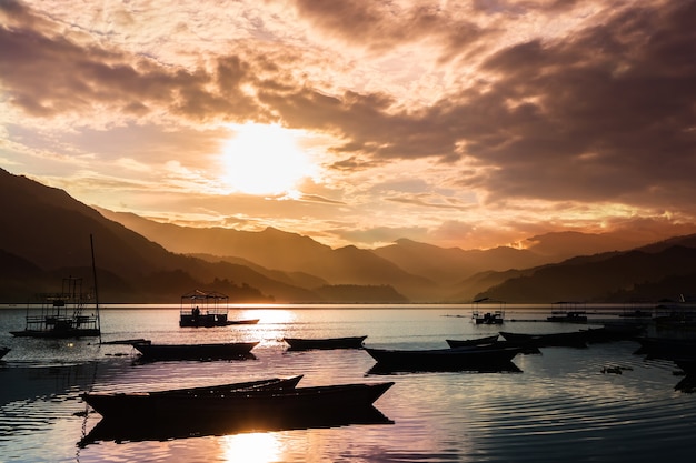 Bellissimo paesaggio con sole al tramonto sul lago Pheva nella città di Pokhara, Nepal. Barche alla luce del tramonto