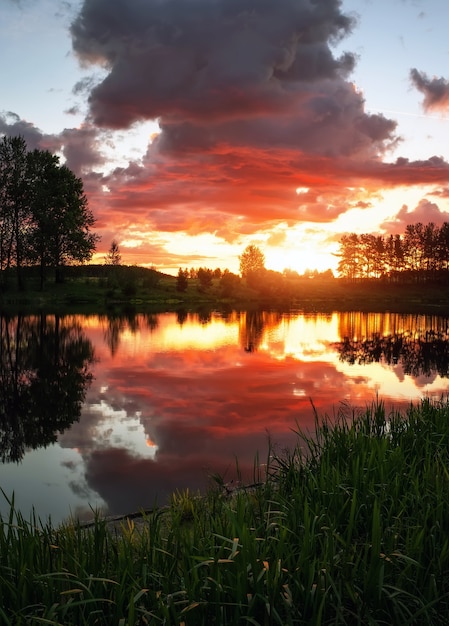 Bellissimo paesaggio con tramonto infuocato sul lago. Vista dalla costa