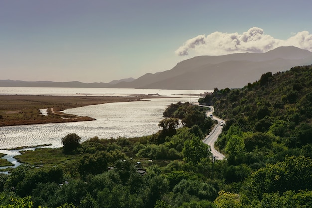 Bellissimo paesaggio con una strada su un pendio di montagna e un fiume coperti di verde