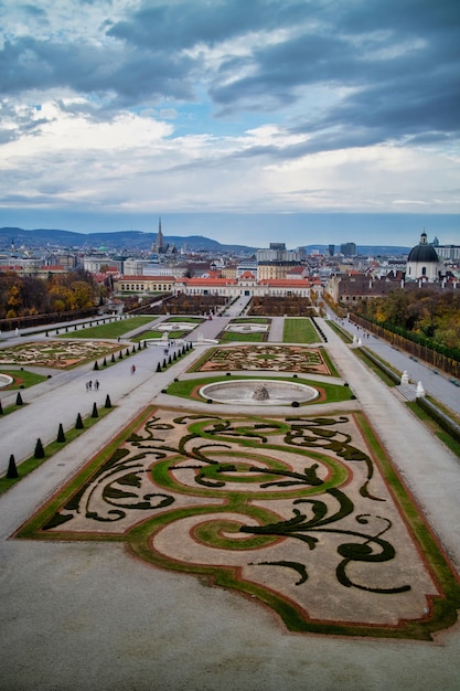 Bellissimo paesaggio del complesso del palazzo Schloss Belvedere e parterre del giardino con piantagione regolare di piante e fiori a Vienna, in Austria, su uno sfondo di cielo nuvoloso.